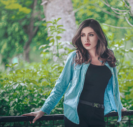 A photo of a woman leaning against a metal railing